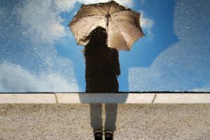 person standing on gray surface while holding umbrella
